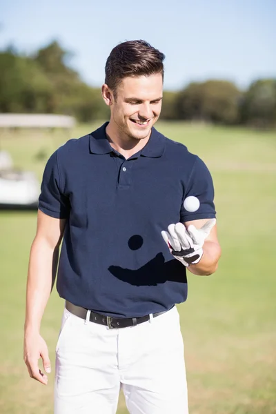 Веселый молодой человек с мячом для гольфа — стоковое фото
