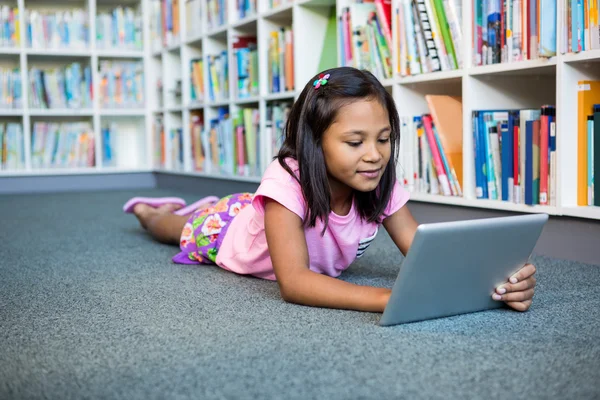 女孩在学校图书馆使用平板电脑 — 图库照片