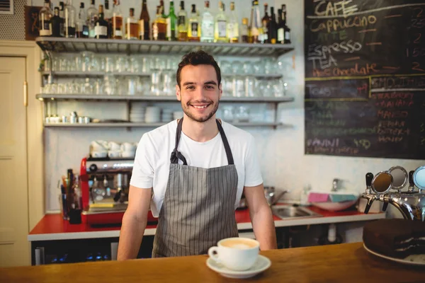 Confident waiter with coffee at counter in cafe — Stock Photo, Image