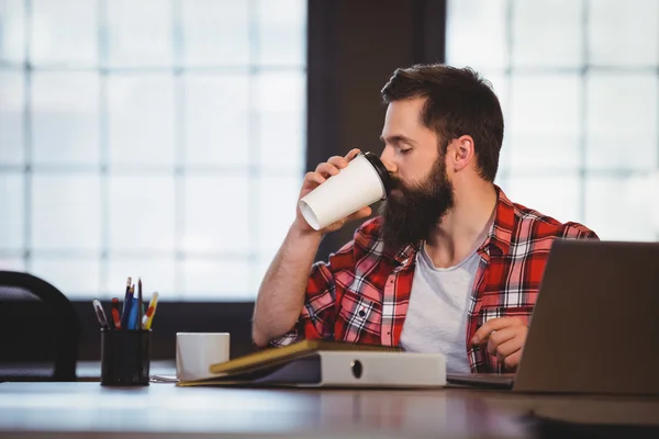 Hipster picia kawy na biurku — Zdjęcie stockowe