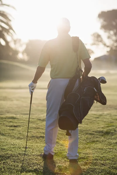 Uomo che trasporta borsa da golf — Foto Stock