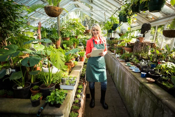 Vrouwelijke tuinman met Klembord op broeikasgassen — Stockfoto