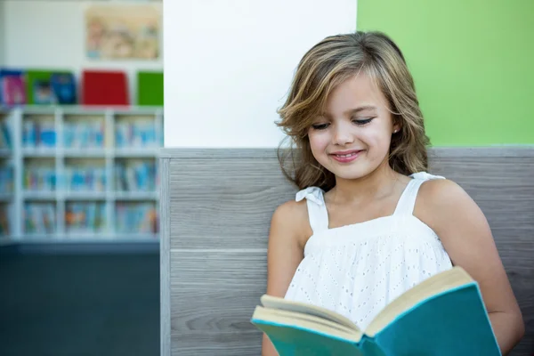Sorridente menina leitura livro — Fotografia de Stock