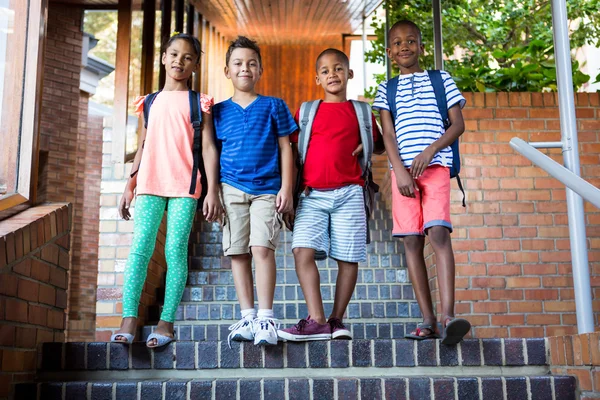 Classmates standing on staircase — Stock Photo, Image