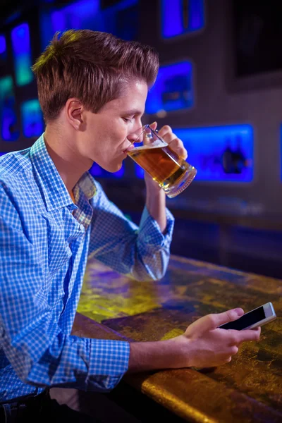 Uomo che beve birra al bancone del bar — Foto Stock
