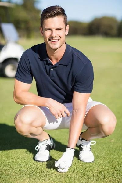 Hombre colocando pelota de golf en la camiseta — Foto de Stock