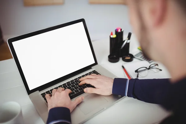 Homem usando laptop na mesa no escritório — Fotografia de Stock