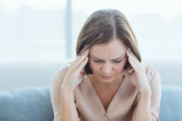 Verkrampte vrouw zitten thuis — Stockfoto