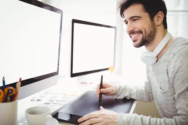 Empresário usando tablet na frente de computadores — Fotografia de Stock