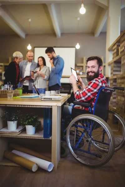 Улыбающийся бизнесмен-инвалид с помощью планшета — стоковое фото