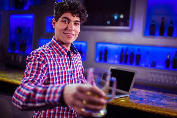 Hombre sosteniendo vaso de cerveza en bar mostrador — Foto de Stock