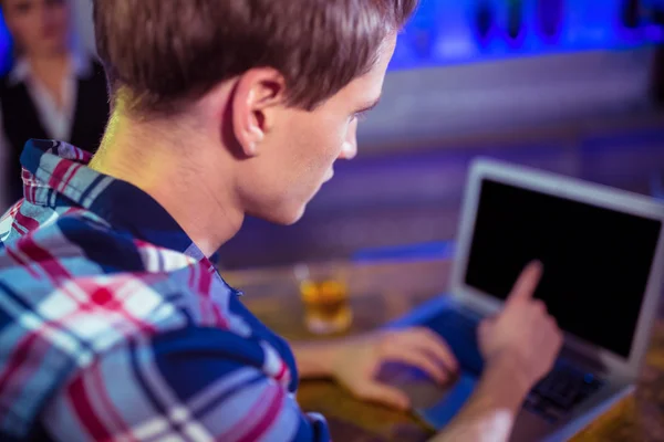 Hombre usando el ordenador portátil en barra de bar — Foto de Stock