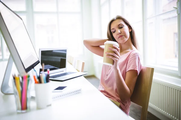 Diseñador cansado sosteniendo taza de café —  Fotos de Stock