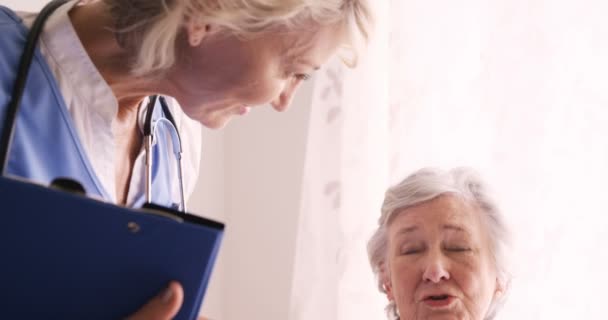 Läkare tröstande till en äldre kvinna — Stockvideo