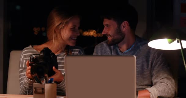 Colegas usando laptop e câmera à noite — Vídeo de Stock