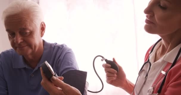 Läkare kontrollerar ett blodtryck av man — Stockvideo
