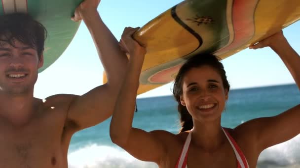 Pareja llevando tabla de surf en su cabeza — Vídeos de Stock