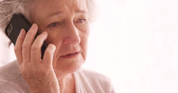 Sad senior woman talking on phone — Stock Video