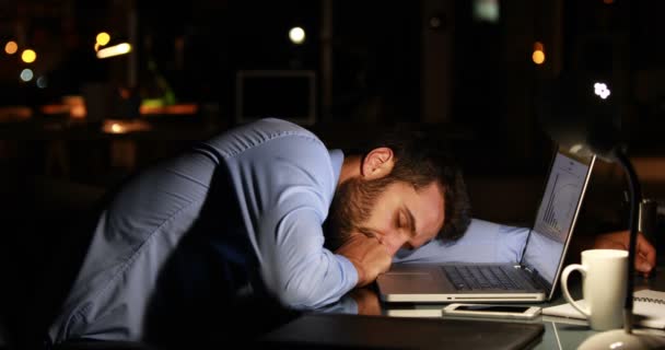 Tired businessman using laptop at night — Stock Video