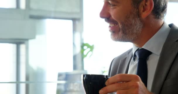 Два улыбающихся человека пьют кофе — стоковое видео