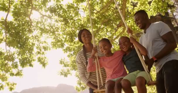 Familie spelen op de schommels — Stockvideo