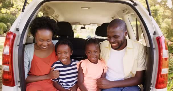 Семья сидит в машине и улыбается — стоковое видео