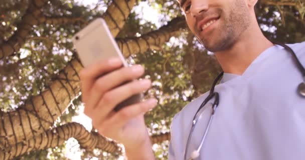 Médico usando telefone celular no quintal — Vídeo de Stock