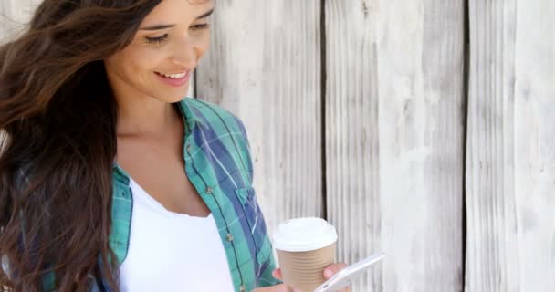 Frau benutzt Handy und trinkt Kaffee — Stockvideo