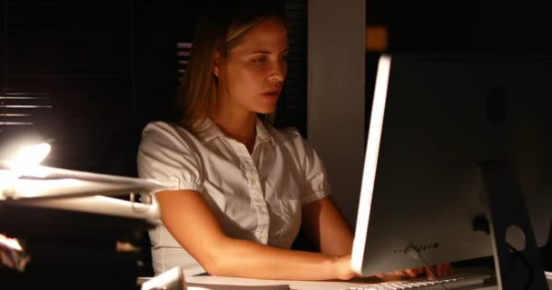 Businesswoman using computer at night — Stock Video