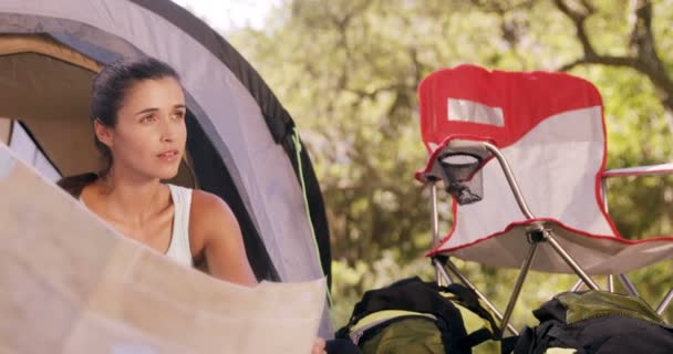 Mulher olhando para um mapa fora da tenda — Vídeo de Stock