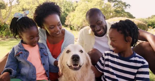Familjen är leende och sitter med en hund — Stockvideo