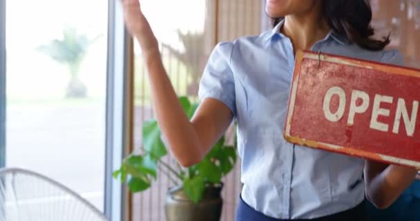 Mujer sonriente sosteniendo un cartel abierto — Vídeo de stock