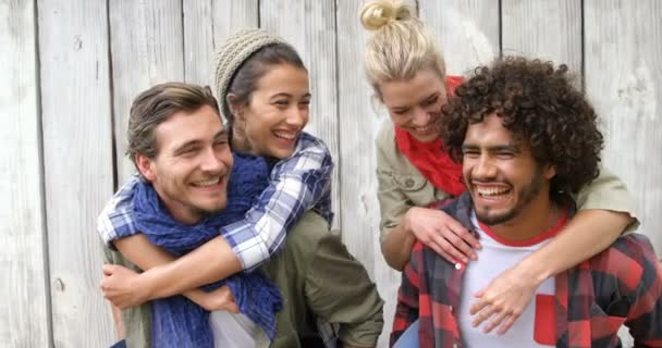 Homens dando passeio de piggyback para as mulheres — Vídeo de Stock