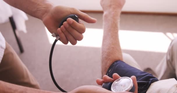 Medico maschio che controlla la pressione sanguigna dell'uomo anziano — Video Stock