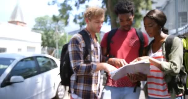 Amici che guardano la mappa mentre la donna clicca fotografia — Video Stock