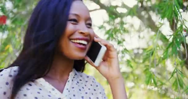 Mujer sonríe y habla por teléfono — Vídeo de stock