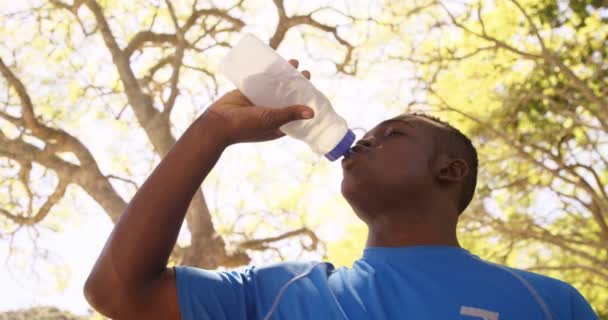 Sportler trinkt auf eine Flasche — Stockvideo