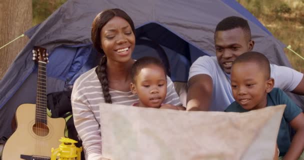 Família olhando para cartão de mapa na frente de uma tenda — Vídeo de Stock
