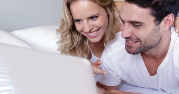 Couple looking at laptop on bed — Stock Video