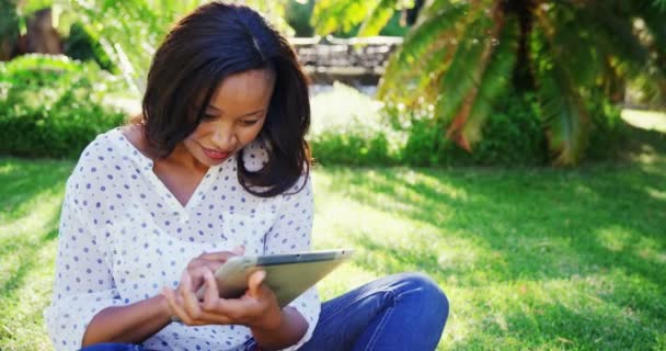 Mujer está sonriendo y usando una tableta — Vídeo de stock