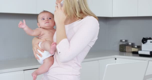 Madre haciendo llamada y sosteniendo a un bebé — Vídeos de Stock