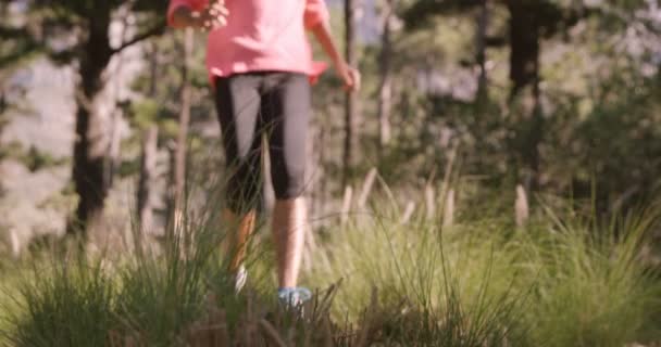 Kvinnan jogging genom skogen — Stockvideo