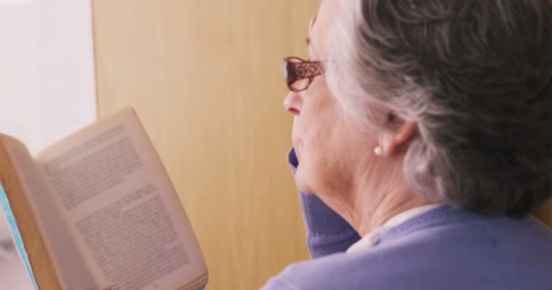 Mulher sênior lendo um romance — Vídeo de Stock