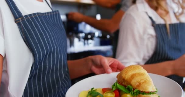 Офіціантка тримає тарілку їжі — стокове відео