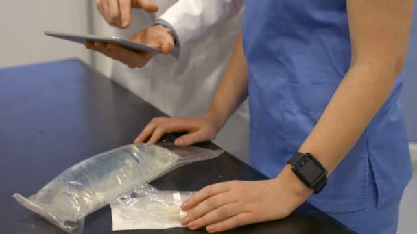 Un veterinario está mostrando su tableta a su asistente — Vídeo de stock