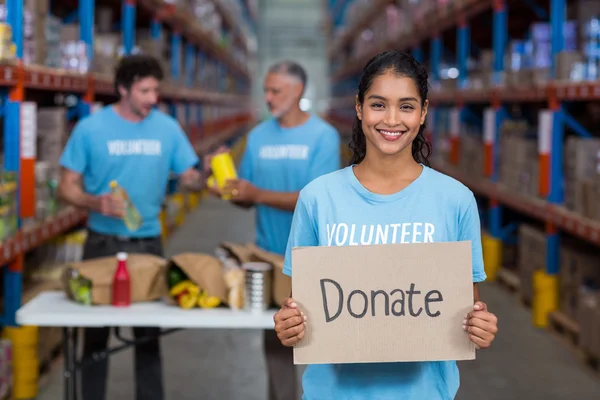 Retrato de voluntário feliz segurando um sinal — Fotografia de Stock