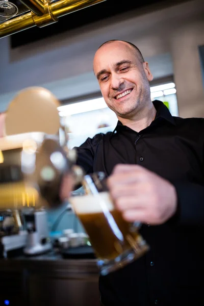 Brewer filling beer in beer glass from beer pump — Stock Photo, Image