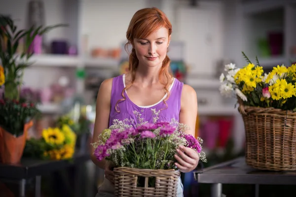 Blumenhändlerin hält Korb mit Blumen — Stockfoto