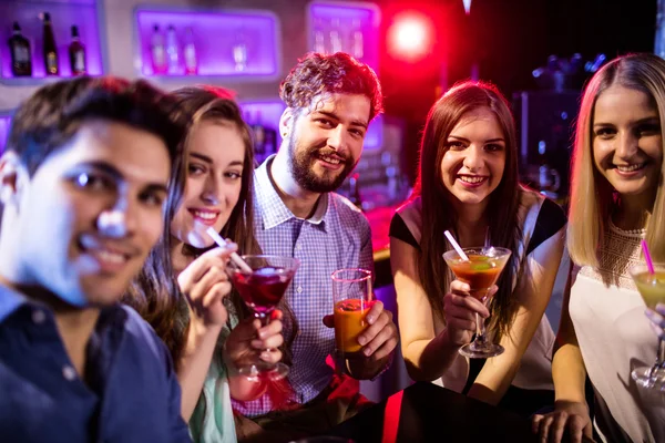 Друзья пьют коктейли за стойкой бара — стоковое фото