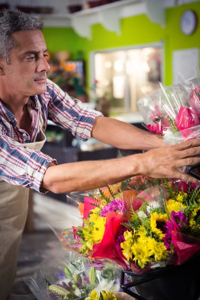 Florista masculino arranjando buquê de flor — Fotografia de Stock